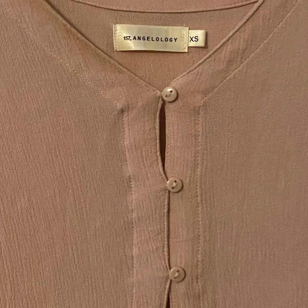 A pink vintage blouse pre loved and use excellent! In a size XS, but can fit a size S since it’s very stretchy. It looks like new and has no noticeable flaws   . Blusar.