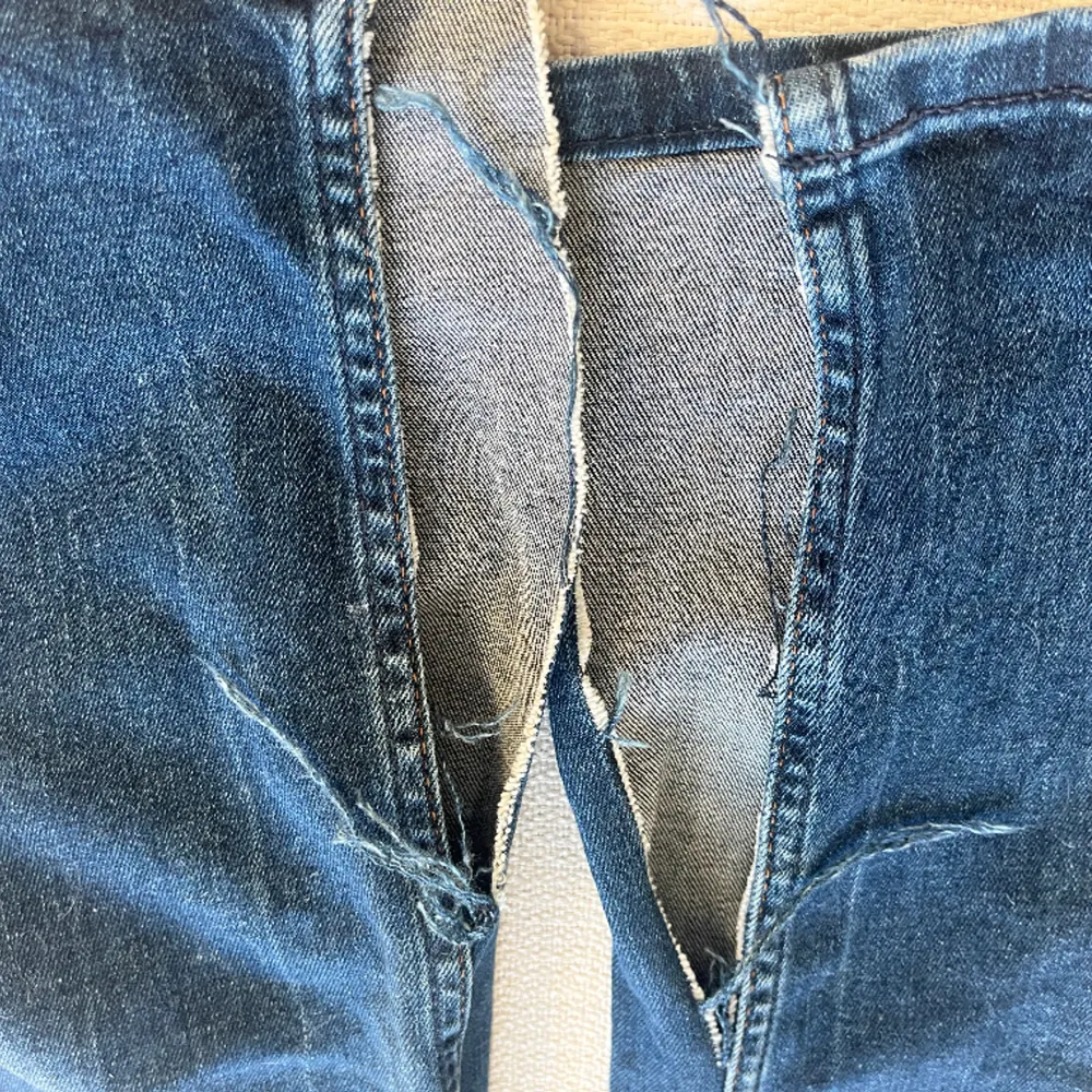 Säljer nu dessa lågmidjade jeans från m.o.d som tyvärr inte passar längre!   Dem är lågmidjade och i flared modell med en slits (se bild 3)som är enkel att sy igen,  men de är en väldigt snygg detalj!   W:26/27  L:32/34 ish Köpare står för frakt❤️ . Jeans & Byxor.