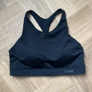 Svart Sportbh/topp Stronger  - Knappt använd. Snygg högre design vid halsen 😍 Bra stöd vid träning (high support). Vadderade kupor. 