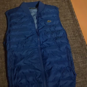 Lacoste väst - En väst i storlek M med väldigt fin och bra passform. Säljer pga att den inte riktigt passa mig i färgen.  Köpt för 2200 kr men säljer för vill bli av med den