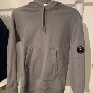 Cp Company hoddie - En grå Cp Company hoddie som är sparsamt använd. Tröjan är i väldigt fint skick 9/10. Storlek S. Det är såklart äkta vara och kvitto finns. Bara att skriva vid minsta frågor.   Nypris 2500-2800.  Mittpris 799.  