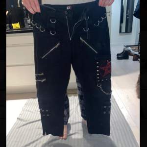 Svarta jeans med kedjor och röd stjärna. Går att ändra till shorts med en dragkedja. Köptes på Bluefox i Stockholm för 900 kr. 