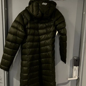 Dunkappa - Fin dunkappa med luva.  Varm och skön med blixtlås längst sidorna för att kunna ta långa steg. Ett litet hål på ena armen som är lagat med en lapp. Grön.