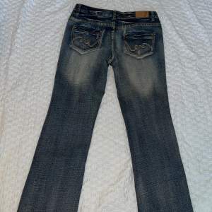 Fina stentvättade jeans med detaljer på backfickorna i jätte bra skick. Midjemåttet är ungefär 42 cm tvärs över. 