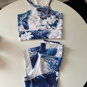 Träningsset Stronger - Tights och crop-top med Hawaii mönster från Stronger, tights stl XS och crop-top stl S. I bra skick men mindre skavanker finns, se bilder!
