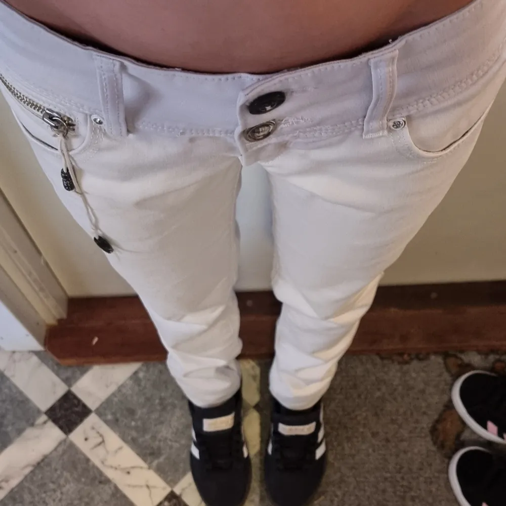Vita lowrise jeans från Crazy Age. Coola detaljer och snitt både fram och bak. Dubbla knappar fram, varav ena knappen är utbytt. Väldigt stretchiga och sköna att ha på sig. Storlek XS/S enligt mått: Midja: 34 CM. Innerbenslängd: 82 CM.. Jeans & Byxor.