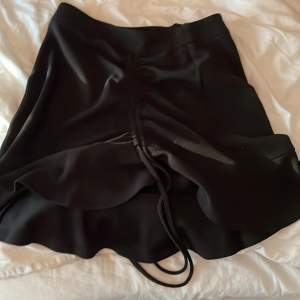 Medellång kjol med band som detalj men även en dragkedja baktill vilket gör att den passar många. Den är i nyskick men kommer ej till användning, perfekt till sommaren!!! 