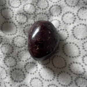 Okänd kristall - Vinröd trumlad kristall. Okänd kristall typ köptes 2022 för 400 kr. Är förmodligen en sällsynt pga av priset men jag har ingen användning för den. 