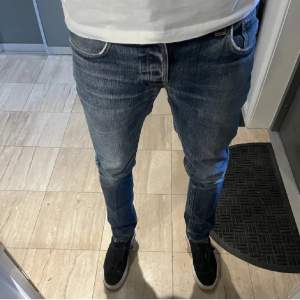 Ett par riktigt feta nudie jeans i modellen Grim Tim. Skicket är 9/10, väldigt sparsamt använda. Ny pris på dessa är 1600kr. (Modellen på bilden är 185, 70kg)