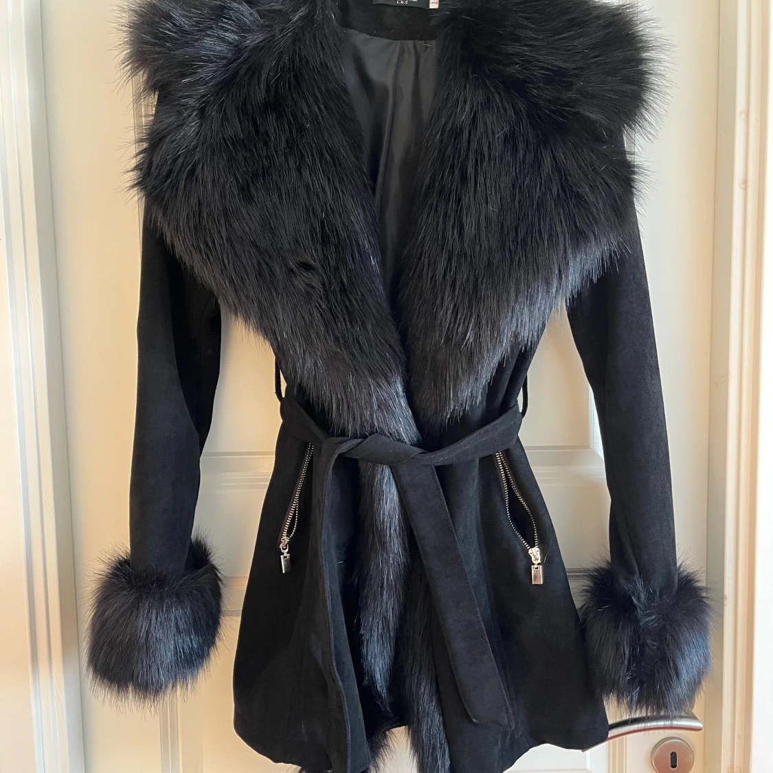 Svart kappa med pälsdetaljer