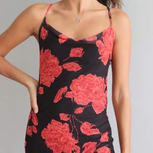 Supersnygg svart/röd klänning med ros mönster. Använd men i bra skick. Svart underklänning med mesh material över.