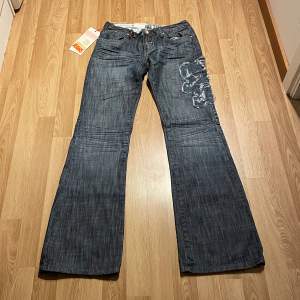(14) lågmidjade bootcut jeans helt nya med lappar kvar med coola detaljer på. Står strlk 29 skulle säga 27/34 men stretchiga. Midjemått rakt över: 36cm, innerbenslängd: 85cm 🩵