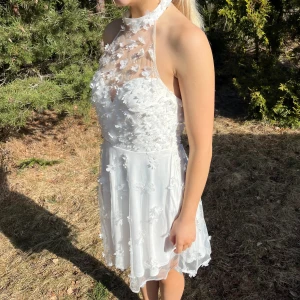 Vit klänning - 💕Moments New York, köpt från bubblerooms hemsida, finns ej kvar där, nypris 1099kr.  🥺Rosévin fläck vänster nertill, brun utan sol fläckar på insidan / kanterna, syns ej på! Perfekt till studenten 💕