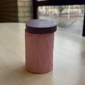 En krymp burk som har en öppnignsbarsida - Den är hemma gjord och gjort med väldigt mycket kärlek och mycket blod,svett,tårar den är väldigt praktisk då den har en öppningsbar sida så blir den väldigt praktiskt ett långfinger högt och omkretsen av en hand. Den är arkitekt ritad. Slutar 29/4 