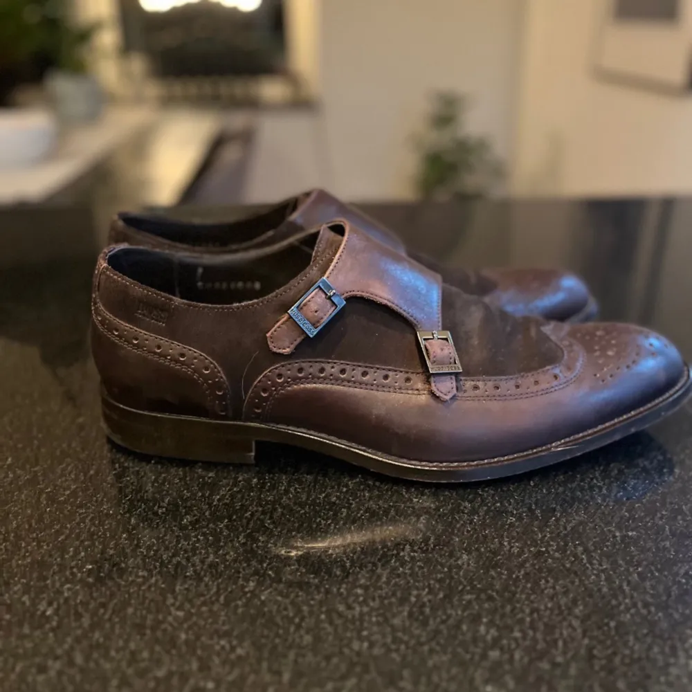 Boss COLBY MONK tillverkade i Italien i blandning av brunn skinn och mocka. Fantastiskt sköna skor, sparsamt använda. Modellnummer 20659088.  Storleken är 7 1/2 vilket motsvara 41 1/2 men kan även användas av dem som har storlek 42.  Innermått 28,2 c. Skor.