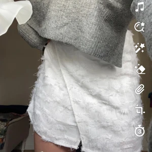 Vit kjol - Sååå fin kjol i lite fjäderliknande material. Knappt i midjan som man stänger med. Aldrig använd då den är för liten. Passar xs-s. Perfekt till mottagningen eller bara en sommaroutfit! LÄS BIO
