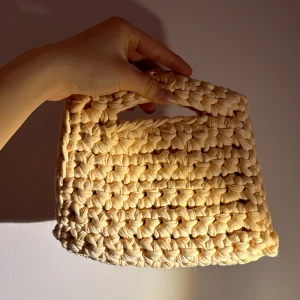 Virkad Väska - En somrig väska virkad i aprikosfärgat trikåtyg💕Den är 23cm bred nedtill och 17cm bred upptill, 18cm i höjd🩷Passar perfekt till våren och sommaren🐚