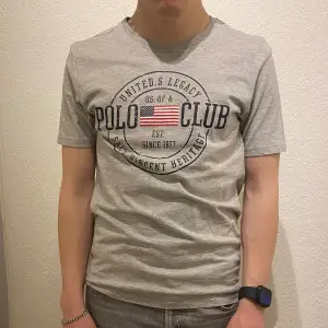 En grå t-shirt från märket Polo Club i storlek S. Produkten är i använt skick men utan några som helst defekter. Hör av er vid frågor!