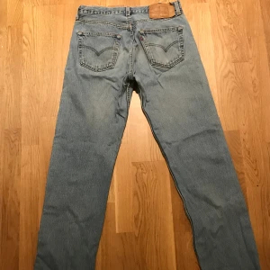Levis 501 W32 - Vintage Levis 501 i fint skick! Ljusblå, urtvättad stil. Sitter lite lösare än nytillverkade 501:or. De är ursprungligen längd 36 men jag har sytt upp dem så de är typ 32/33 i längd (se söm på sista bilden)