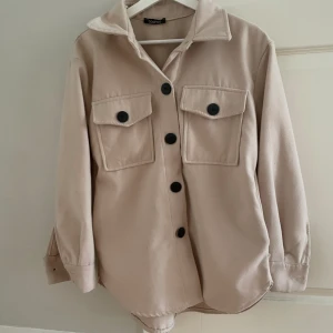 Beige kappa  - Mellanlång. I mycket bra skick, knappt använd. 