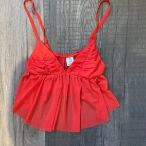 Rött linne  - Rött linne från Urban Outfitters i tunnt material. Köpte för ett år sedan men har aldrig känt att den passar mig. Inga slitningar eller hål, nyskick. Storlek s passar bra på mig som vanligtvis har xs/s. Nypris 350kr🫶🏻