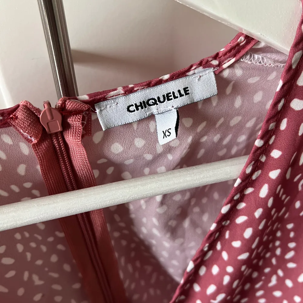 Jättefin röd/rosa klänning med vita prickar, från Chiquelle. Storlek Xs Skicket är jättebra, som ny. Endast använd några få gånger. Säljer då den inte passar mig längre.. Klänningar.