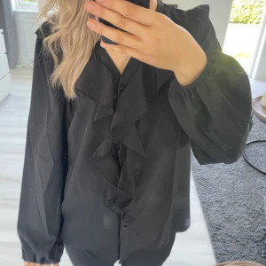 Volang topp svart  - En svart volang topp, vet ej inte vart denna är ifrån pgr av att lappen är kvar och den är ganska gammal! I gott skick och använda fåtal gånger! Jätte söt men lite för lång på mig som är 167! 💞☺️ Hör av dig vid intresse eller mer information/bilder 🤗