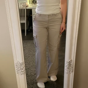 H&M raka cargobyxor  - Säljer dessa cargobyxor i ”ljus gråbeige” då de inte kommer till användning. Nyskick då de endast är använda någon enstaka gång. Inga fläckar eller andra defekter. Nypris 249kr.