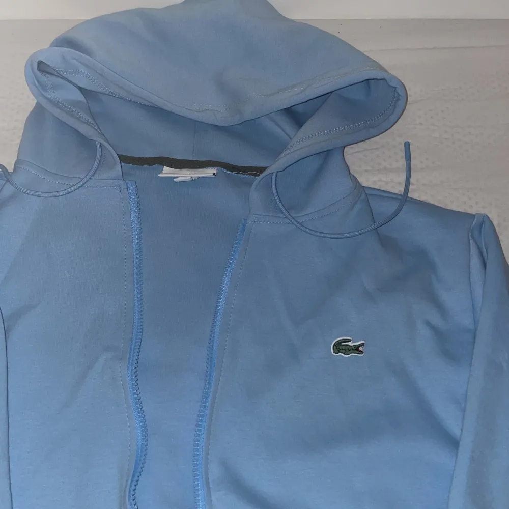 Lacoste zipp hoodie i storlek S.  Aldrig använts då den var för liten.. Hoodies.