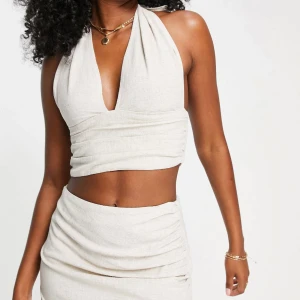 Topp i linne - Helt ny linne topp med knytning i halsen och öppen rygg! Supersnygg, storlek 36 men skulle säga att den passar en XS, 34, bättre.