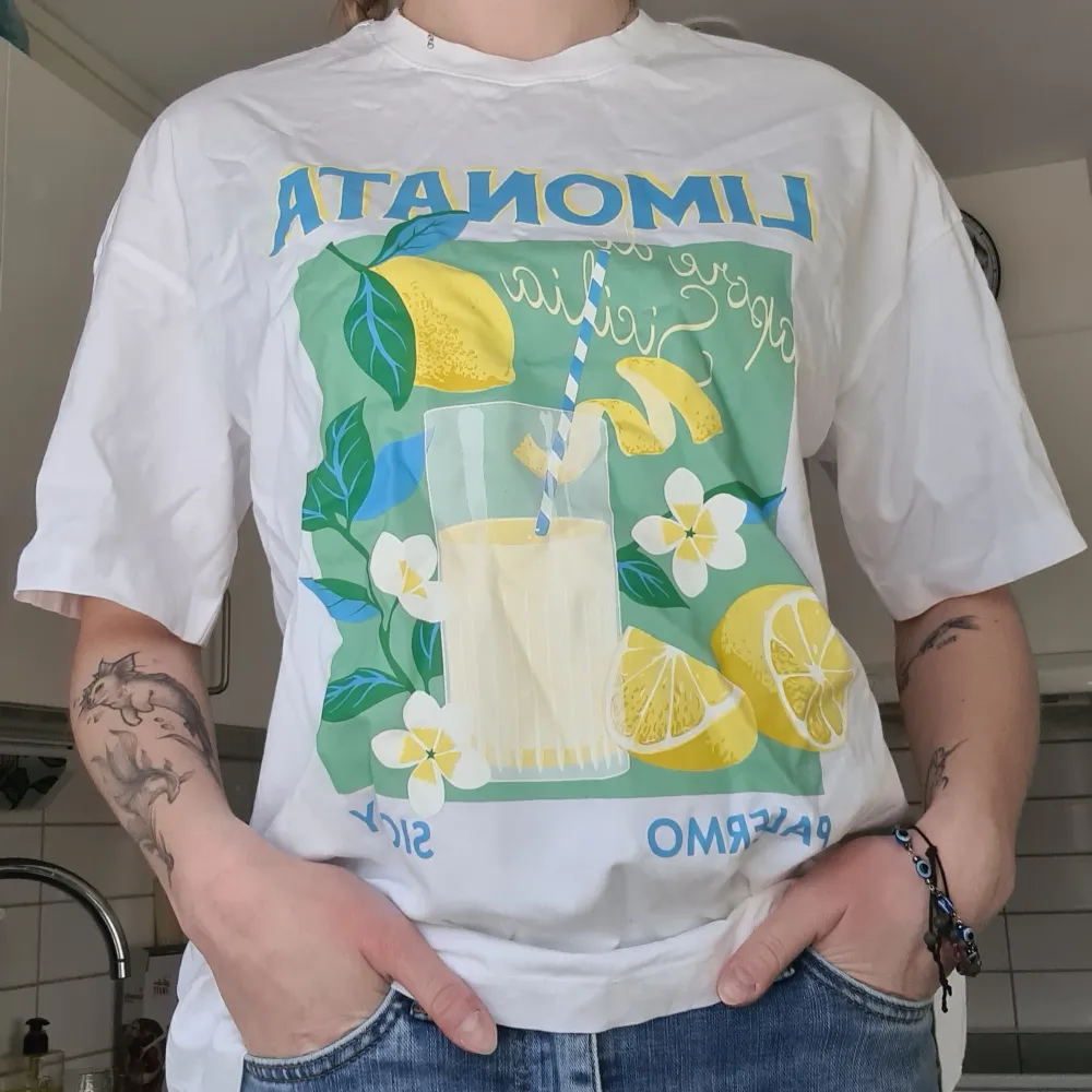 Limonata tryck på vit t-shirt. Aldrig använd, lappen kvar, nypris 199kr. Oversize modell så den är större i storleken. Kom med prisförslag 😊  Material: 100% Bomull.. T-shirts.