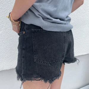 ZARA jeansshorts - Jeansshorts i urtvättad svart/grå med slitningar från Zara🤍 Storlek 40 men sitter bra på mig som har S. (Finns fler produktbilder vid intresse) 