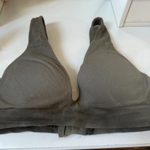 Militärgrön Bygel Bh  - Militärgrön Bygel Bh från H&M  Har tyvärr klippt av lappen men skulle säga att den passar storlek 70-80B Säljer för 25kr exklusive frakt  Den är lite smutsig invändigt men inget som syns när den är på! 