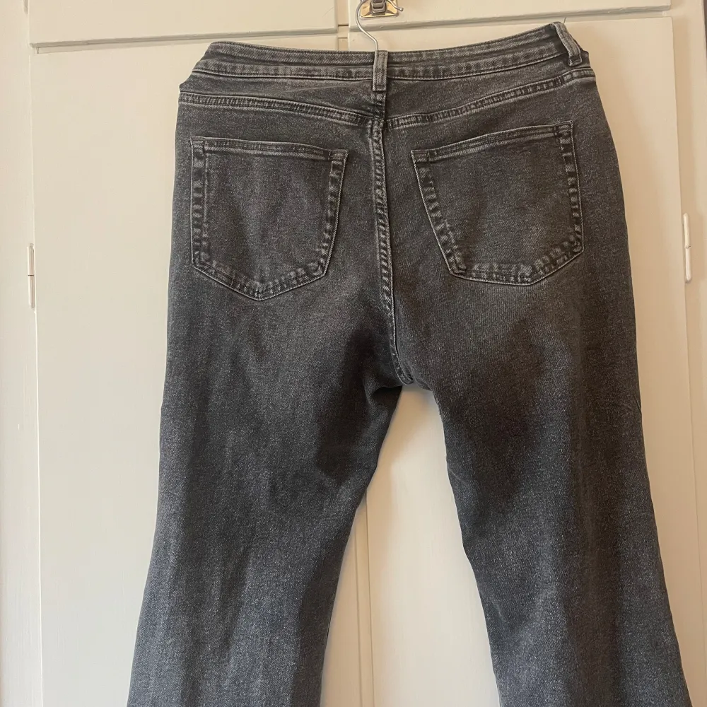 Ett par gråa bootcutjeans. Dom är använda men har ej synliga tecken förutom slitet där nere. Säljer pga att dom är för stora. Jeans & Byxor.