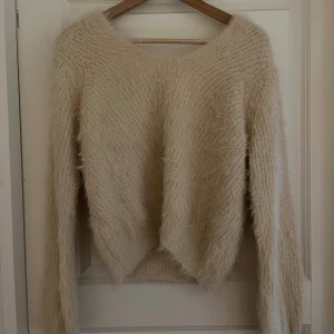 Beige stickad tröja - Stickad V-ringad tröja i jättebra skick. Den är storlek i 32, men något stor i modellen. Bättre anpassad för storlek 36 - 40.