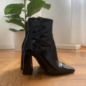 Stövletter med klack - Ett par eleganta, blanka stövletter med hög klack. I gott skick, sparsamt använda! Vissa matta repor på insidan klackarna, men inget som syns om man inte tittar noga. Klackhöjd 9 cm. 