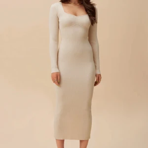 Adoore Roma Dress - Roma midi dress i färgen creme white. Ribbstickad och figurnära i stretchigt materials Hjärtformad ringning och en liten slits i bak. Storlek 38 men passar åtminstone en 40 också. Anänd ett fatal ganger, ser ut som ny. Nypris 1395kr