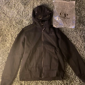 CP Company Hoodie - En fet cp company hoodie 1 : 1, skönt material och bra kvalite. Strl L men passar medium, helt ny och ettiketten sitter kvar fortfarande. Cp company påse följer med  Vid mer frågor eller funderingar är det bara att höra av sig ! 