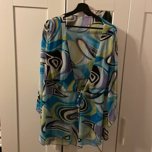 Genomskinlig mönstrad klänning  - En genomskinlig klänning att ha över bikinis eller baddräkt. Aldrig använd, så den är i väldigt bra skick 