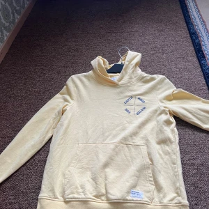 Gul hoodie  -  Säljer den här jättefina gula tröjan har ett litet mönster i brösten men är inte st den är ljus gul bra skick nästan aldrig använt Skriv vid intresse