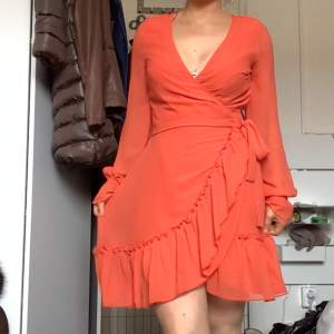 Snygg klänning i orangefärg från Ginatricot i storlek 34, använd fåtal gånger 
