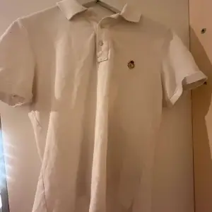 Jättefin vit, nästan aldig använd piké tröja från Ralph rauren med ett annulunda märke på framsidan💕 använt  fåtal gånger och pris kan diskuteras🥰
