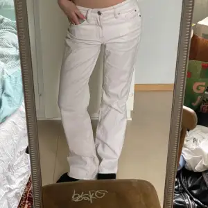 Straight/flared vita/ljusrosa jeans med snygg detalj på fickorna.