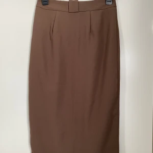 Kjol strl 38 - Säljes i nyskick- aldrig använd!  Fickor och slits bak.