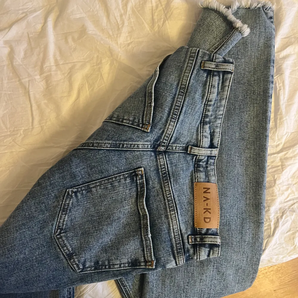 Jeans från NA-KD med slitningar längst ner och stretchiga material. Storlek 36. Inga fläckar . Jeans & Byxor.