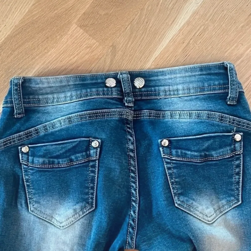 fina blåa lågmidade jenns med fickor och knappar . Jeans & Byxor.