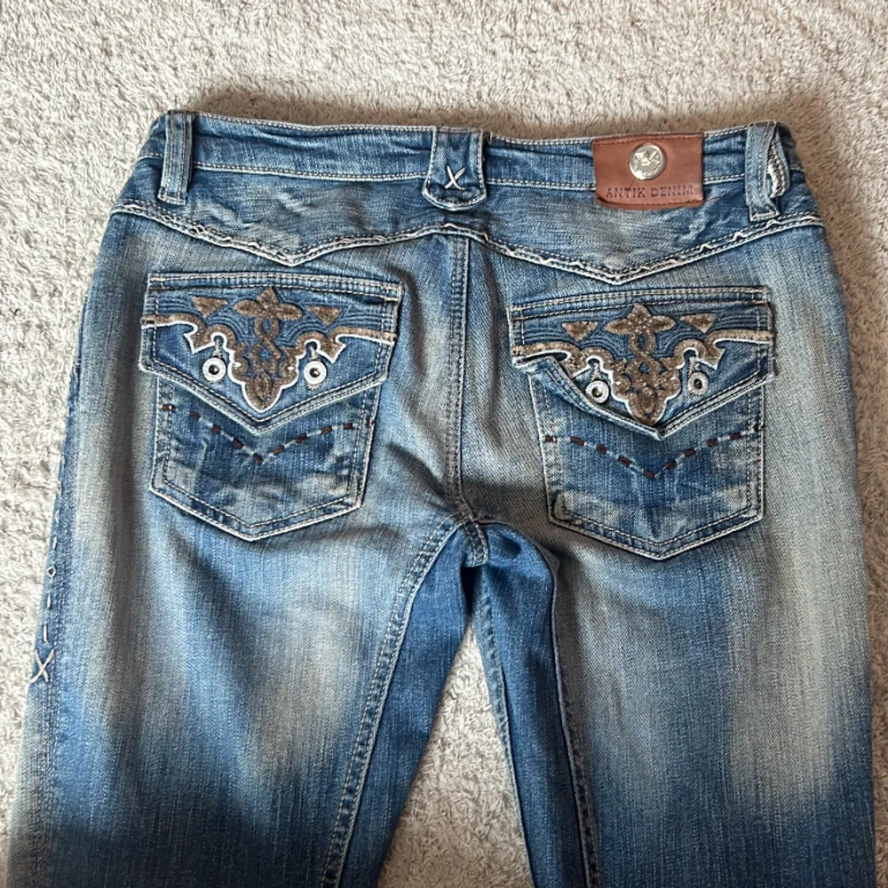 Ascoola vintage lågmidjade bootcut jeans med snygga detaljer. Lite slitning längst ner på vänster ben.  Midjemåttet är ungefär 39 cm och innerbenslängden är 79 cm💓Lite lösa på mig som vanligtvis är strl 36. Kan skicka mer bilder vid begäran💘. Jeans & Byxor.