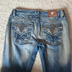 Ascoola vintage lågmidjade bootcut jeans med snygga detaljer. Lite slitning längst ner på vänster ben.  Midjemåttet är ungefär 39 cm och innerbenslängden är 79 cm💓Lite lösa på mig som vanligtvis är strl 36. Kan skicka mer bilder vid begäran💘