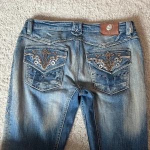 Lågmidjade jeans - Ascoola vintage lågmidjade bootcut jeans med snygga detaljer. Lite slitning längst ner på vänster ben.  Midjemåttet är ungefär 39 cm och innerbenslängden är 79 cm💓Lite lösa på mig som vanligtvis är strl 36. Kan skicka mer bilder vid begäran💘