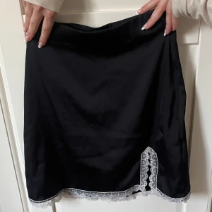 Söt Svart kjol med vit spets - Superfin satinkjol med ett slit på sidan, använd 1 gång. 